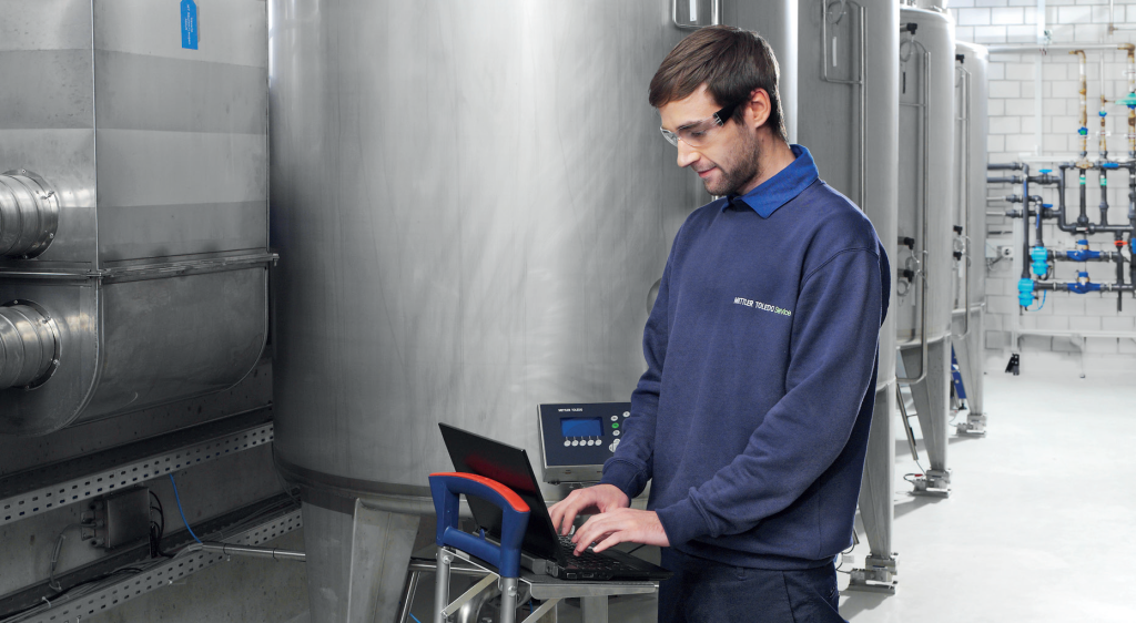 Tech working on a laptop and tank system